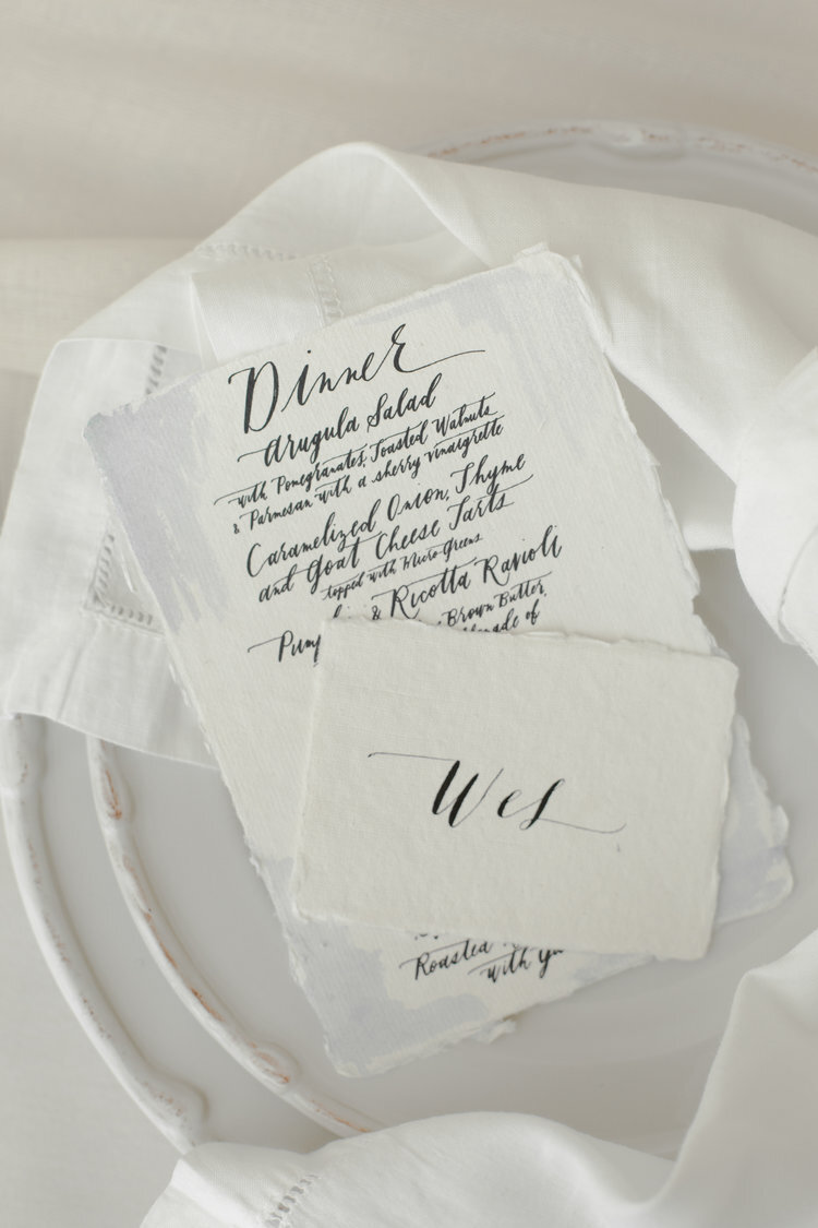 White wedding dishes, linens, menus, and place cards with black accents